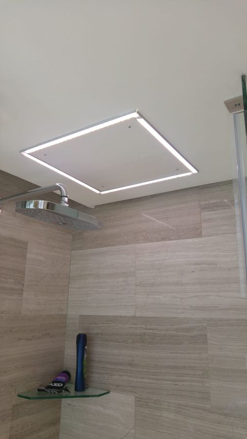 A square LED profile light recessed into a bathroom ceiling