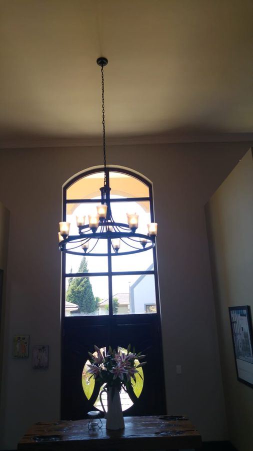 A chandelier hanging in a double-volume entrance hall