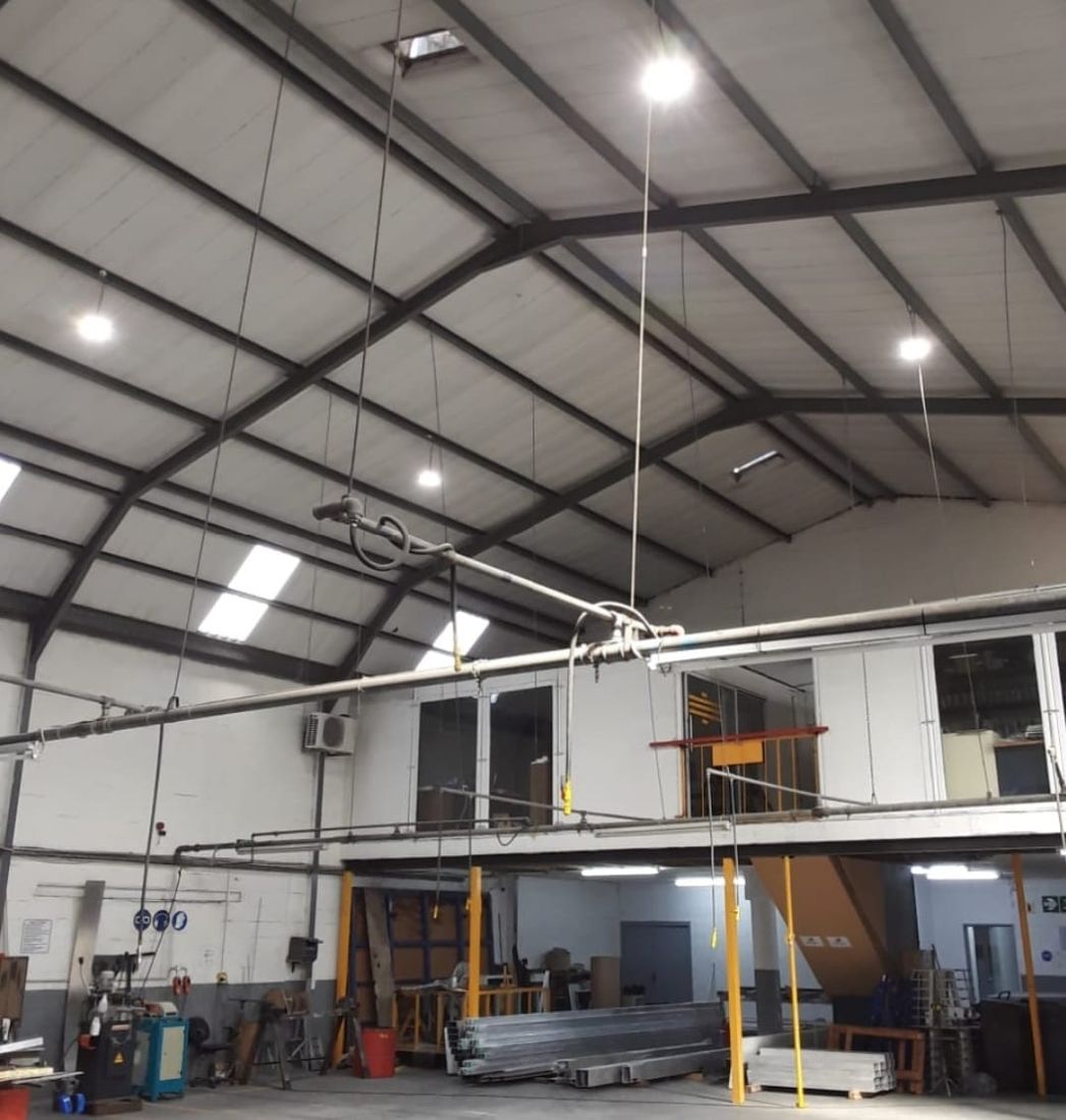High-bay lights hanging from the roof of a factory workshop
