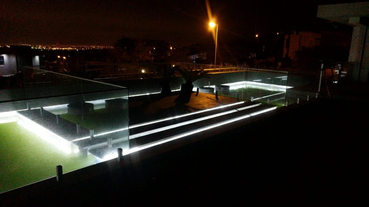 LED strip lighting under terrace steps and along a glass balustrade at night